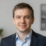Портрет уверенного российского бизнесмена с дружелюбным взглядом на размытом нейтральном фоне студии