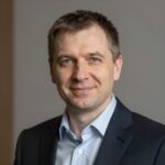 Портрет уверенного российского бизнесмена с дружелюбным взглядом на размытом нейтральном фоне в студии